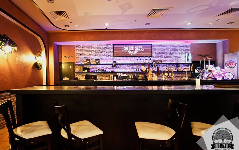 Барная стойка и дверь на кухню в кафе Coffee Shot